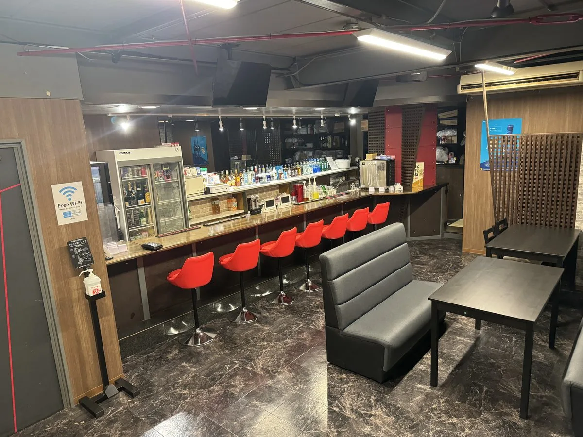 たまりBarの店内。茶色のカウンターと赤い椅子